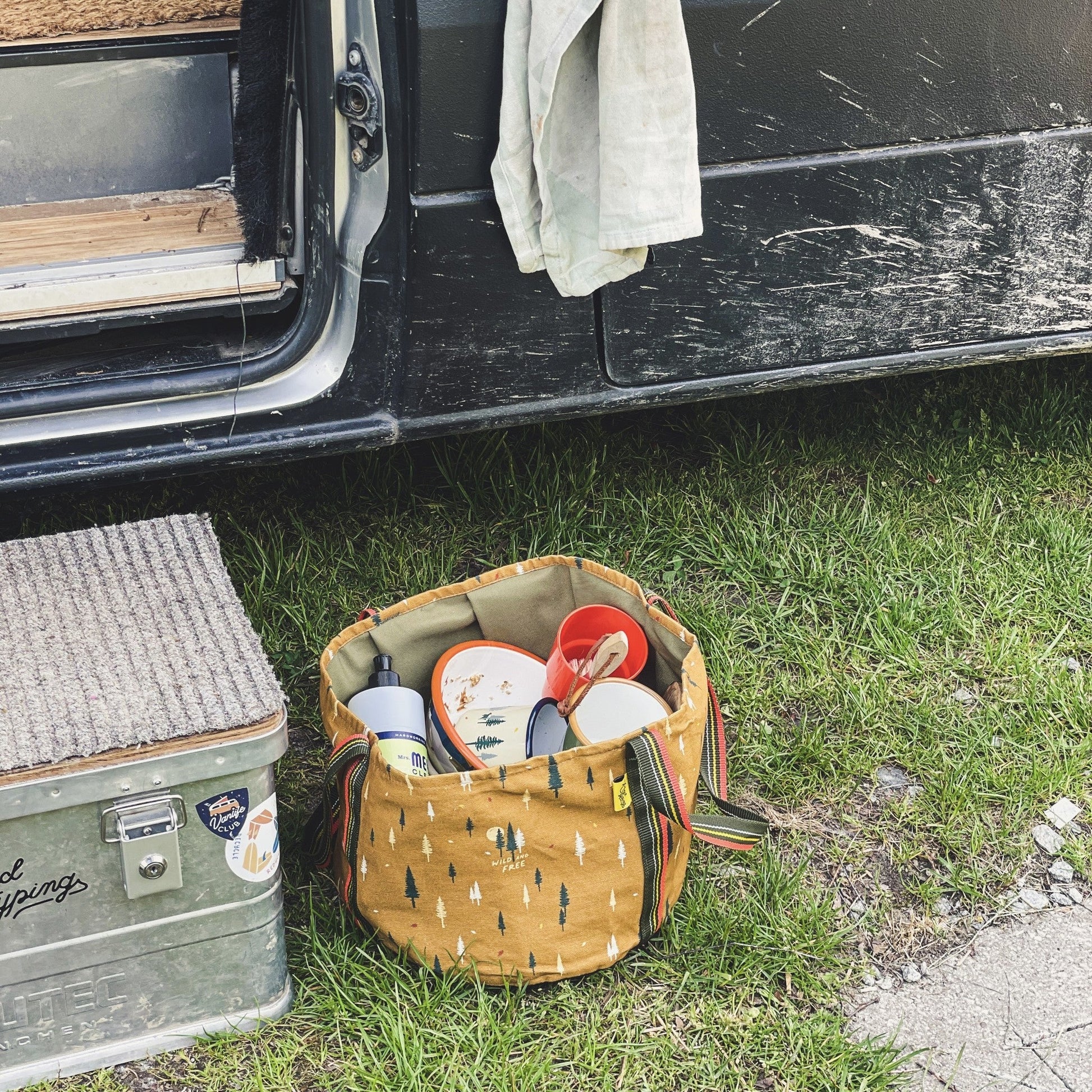 Multifunktionaler Eimer aus Stoff mit schmutzigem Geschirr vor dem Wohnmobi auf dem campingplatz